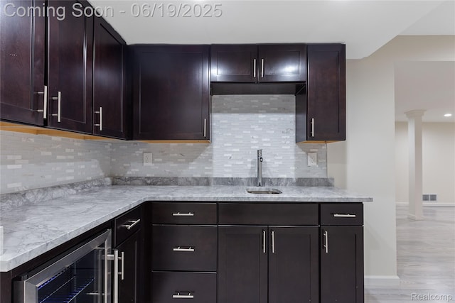 7382 Gateway Dr, West Bloomfield, MI 48322 - kitchen featuring beverage cooler, decorative columns, backsplash, and light wood finished floors