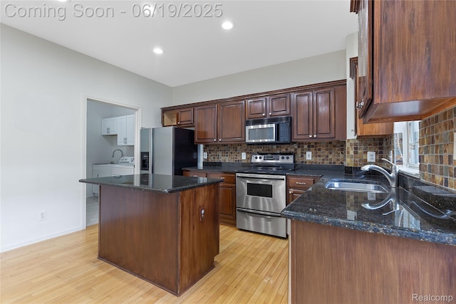 7382 Gateway Dr, West Bloomfield, MI 48322 - kitchen featuring stainless steel appliances, backsplash, a kitchen island, light wood-style floors, and recessed lighting