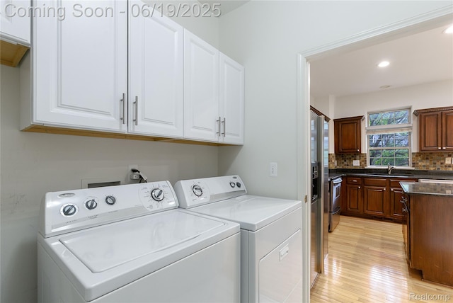 7382 Gateway Dr, West Bloomfield, MI 48322 - washroom with washing machine and clothes dryer, cabinet space, light wood-type flooring, and recessed lighting