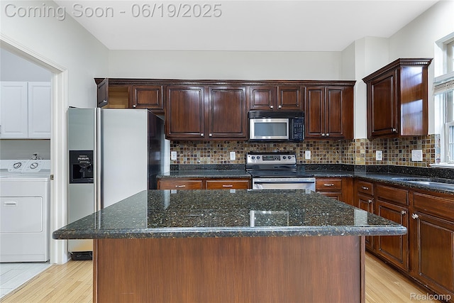 7382 Gateway Dr, West Bloomfield, MI 48322 - kitchen featuring appliances with stainless steel finishes, washer / dryer, light wood-type flooring, and decorative backsplash