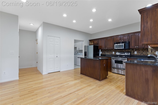 7382 Gateway Dr, West Bloomfield, MI 48322 - kitchen with stainless steel appliances, separate washer and dryer, a center island, backsplash, and recessed lighting