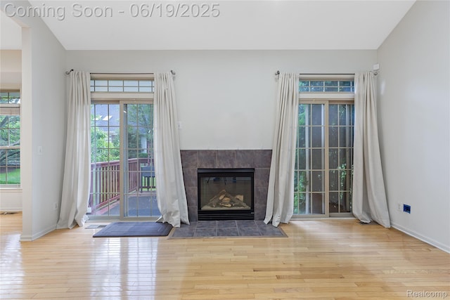 7382 Gateway Dr, West Bloomfield, MI 48322 - unfurnished living room with hardwood / wood-style flooring and a tile fireplace