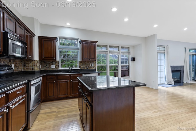 7382 Gateway Dr, West Bloomfield, MI 48322 - kitchen featuring appliances with stainless steel finishes, light wood finished floors, backsplash, a kitchen island, and recessed lighting