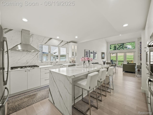 6420 Apple Grove Ln, Bloomfield Hills, MI 48301 - kitchen featuring wall chimney range hood, recessed lighting, light stone counters, a kitchen island, and white cabinetry