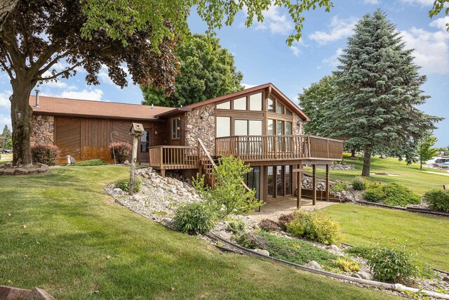 1653 Manchester Way, Gladwin, MI 48624 - rear view of house featuring stone siding, a deck, and a yard
