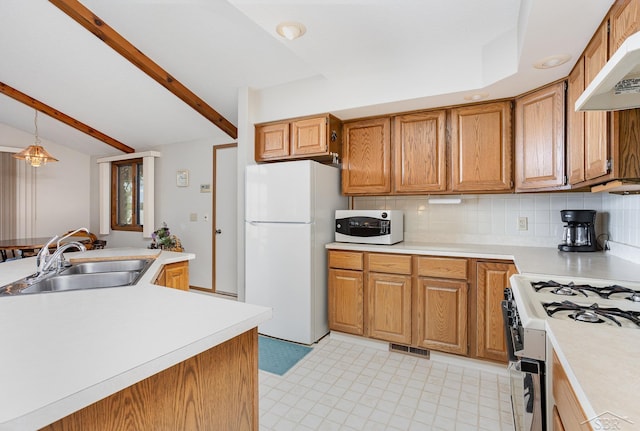 1653 Manchester Way, Gladwin, MI 48624 - kitchen featuring white appliances, under cabinet range hood, light countertops, brown cabinets, and backsplash