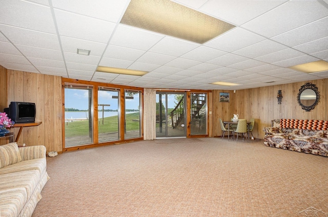 1653 Manchester Way, Gladwin, MI 48624 - living area featuring wood walls, carpet, and a drop ceiling