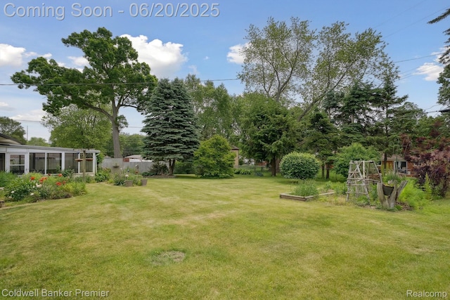 8077 Casa Mia Dr, White Lake, MI 48386 - view of grassy yard featuring a vegetable garden and a sunroom