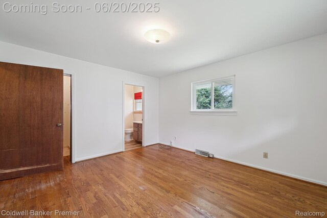 8077 Casa Mia Dr, White Lake, MI 48386 - unfurnished bedroom featuring wood finished floors and ensuite bath