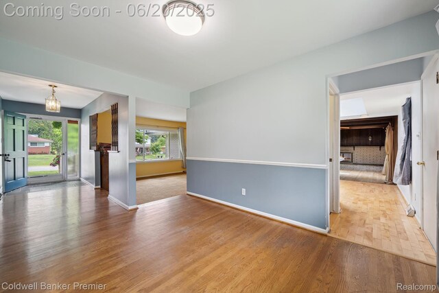 8077 Casa Mia Dr, White Lake, MI 48386 - unfurnished living room featuring wood finished floors and a chandelier