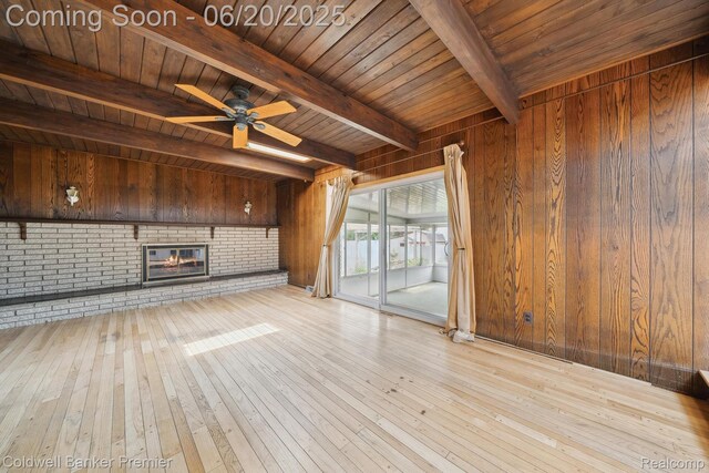 8077 Casa Mia Dr, White Lake, MI 48386 - unfurnished living room with wood walls, hardwood / wood-style floors, a wood ceiling with exposed beams, a brick fireplace, and ceiling fan