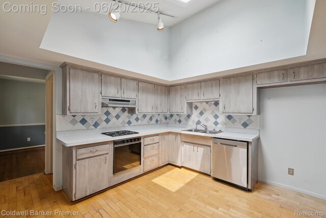 8077 Casa Mia Dr, White Lake, MI 48386 - kitchen with wall oven, stainless steel dishwasher, under cabinet range hood, light countertops, and decorative backsplash