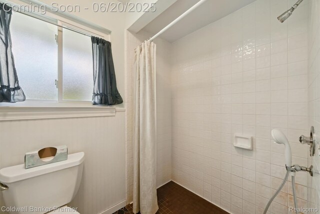 8077 Casa Mia Dr, White Lake, MI 48386 - bathroom with tiled shower and a wainscoted wall