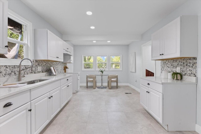 18419 Faust Ave, Detroit, MI 48219 - kitchen with tasteful backsplash, white cabinets, recessed lighting, light tile patterned floors, and light stone countertops