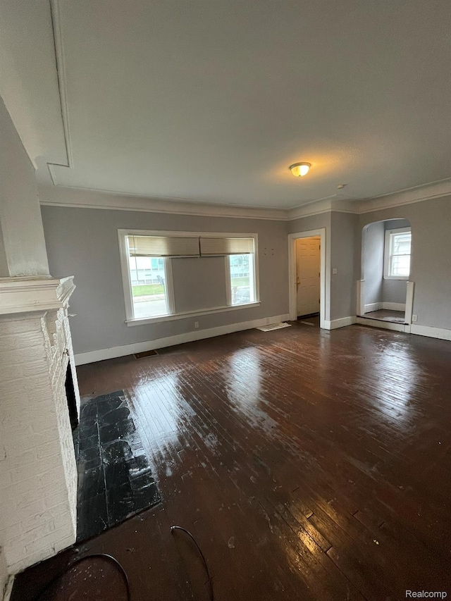 14200 Whitcomb St, Detroit, MI 48227 - unfurnished living room featuring ornamental molding, wood-type flooring, a fireplace, and arched walkways