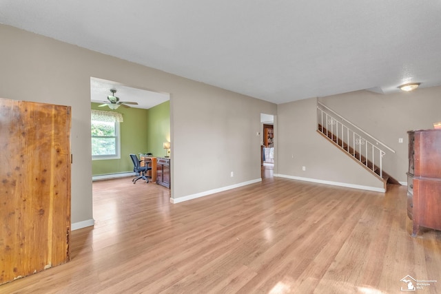 234 Crampton Dr, Monroe, MI 48162 - unfurnished living room featuring light wood-type flooring, an office area, stairs, and a baseboard heating unit