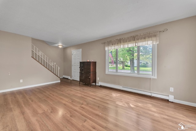 234 Crampton Dr, Monroe, MI 48162 - unfurnished living room featuring baseboard heating, light wood-style flooring, and stairway