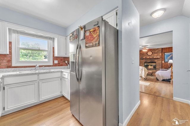 234 Crampton Dr, Monroe, MI 48162 - kitchen featuring stainless steel fridge with ice dispenser, light wood-type flooring, white cabinets, and a fireplace