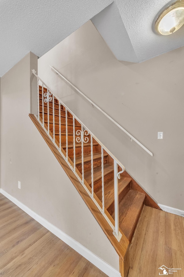 234 Crampton Dr, Monroe, MI 48162 - stairs featuring a textured ceiling and wood finished floors