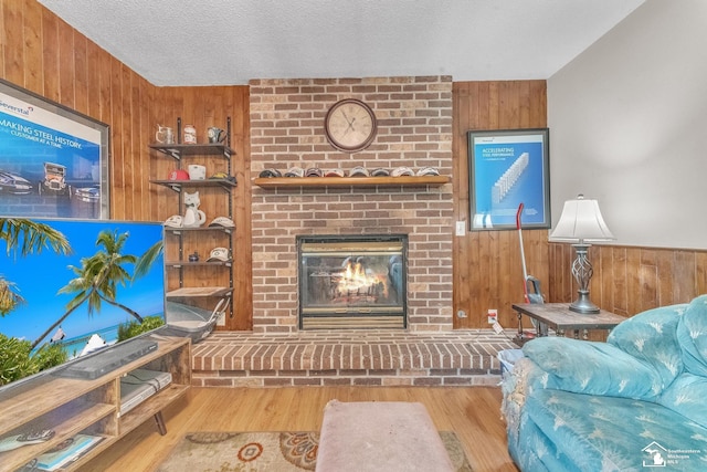 234 Crampton Dr, Monroe, MI 48162 - living area with wood walls, a brick fireplace, wood finished floors, and a textured ceiling