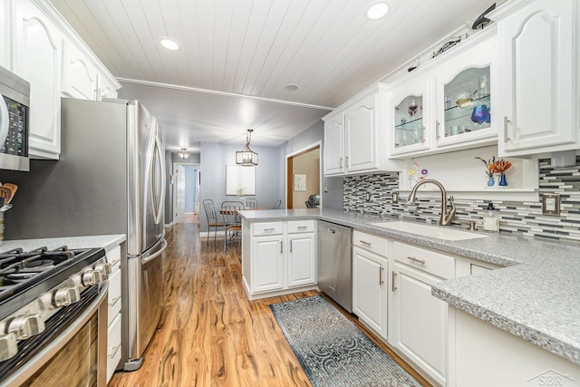 4170 Clement Dr, Saginaw, MI 48603 - kitchen with stainless steel appliances, a peninsula, light wood-style flooring, white cabinets, and recessed lighting