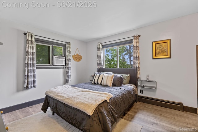 527 Tanview Dr, Oxford, MI 48371 - bedroom featuring multiple windows, cooling unit, a baseboard heating unit, and wood finished floors