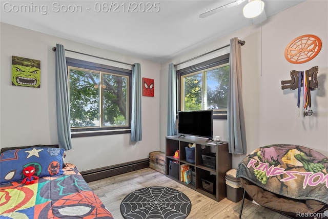 527 Tanview Dr, Oxford, MI 48371 - bedroom featuring multiple windows, a baseboard heating unit, wood finished floors, and ceiling fan