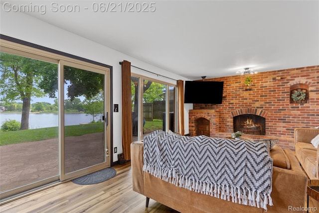 527 Tanview Dr, Oxford, MI 48371 - living area with a water view, wood finished floors, and a brick fireplace