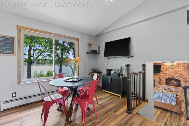 527 Tanview Dr, Oxford, MI 48371 - dining space featuring vaulted ceiling, a baseboard radiator, and wood finished floors