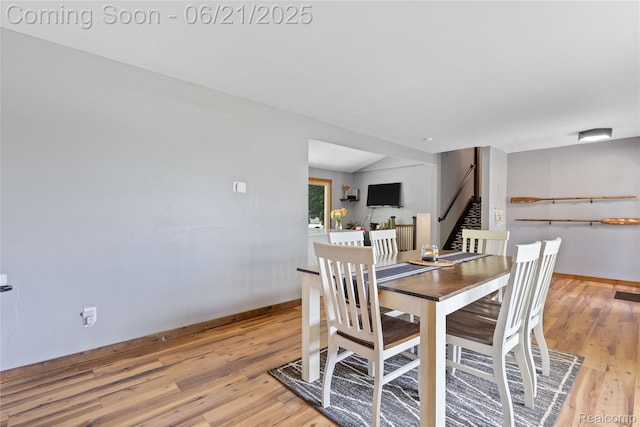 527 Tanview Dr, Oxford, MI 48371 - dining room featuring light wood-type flooring, stairway, and vaulted ceiling