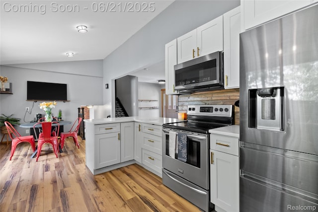 527 Tanview Dr, Oxford, MI 48371 - kitchen featuring stainless steel appliances, lofted ceiling, a peninsula, light countertops, and white cabinetry