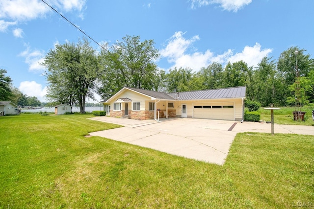 9760 Lime Lake Rd, Hudson, MI 49247 - single story home featuring a garage, concrete driveway, a front lawn, stone siding, and a metal roof