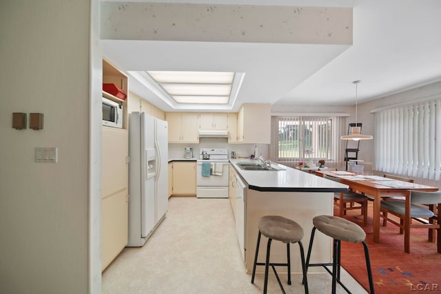 9760 Lime Lake Rd, Hudson, MI 49247 - kitchen featuring white appliances, a peninsula, under cabinet range hood, and cream cabinetry