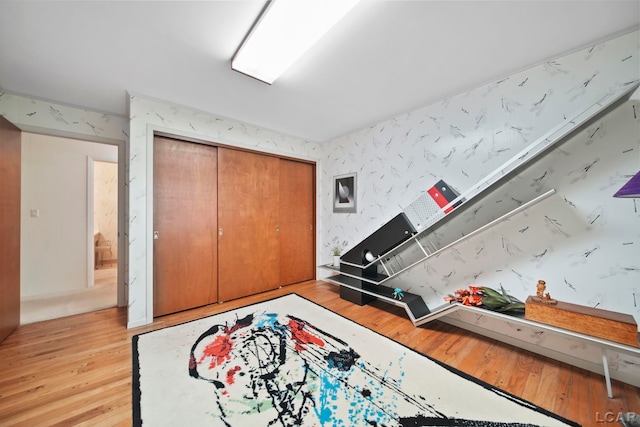 9760 Lime Lake Rd, Hudson, MI 49247 - bedroom featuring light wood-type flooring, a closet, and wallpapered walls