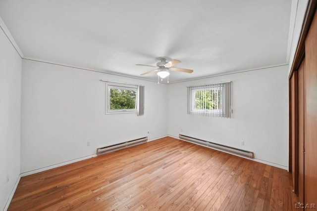 9760 Lime Lake Rd, Hudson, MI 49247 - unfurnished room featuring baseboard heating, plenty of natural light, and hardwood / wood-style flooring