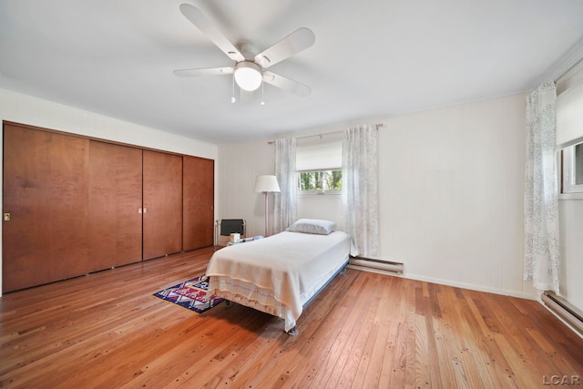 9760 Lime Lake Rd, Hudson, MI 49247 - bedroom featuring light wood-type flooring, a baseboard radiator, ceiling fan, and a closet