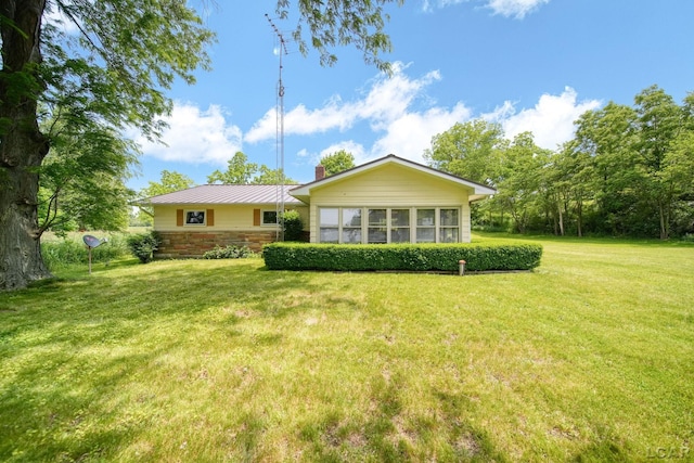 9760 Lime Lake Rd, Hudson, MI 49247 - back of house with a yard, a chimney, and a metal roof