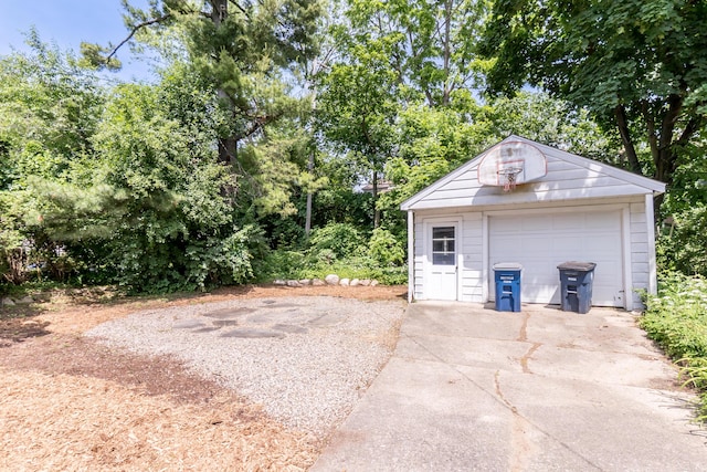 1215 Prescott Ave, Ann Arbor, MI 48103 - detached garage with concrete driveway and view of wooded area