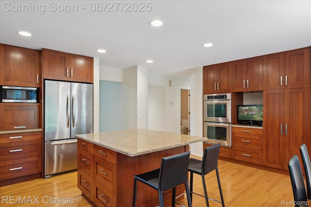 35606 Huntsman Ct, Farmington Hills, MI 48331 - kitchen with appliances with stainless steel finishes, light wood-type flooring, a breakfast bar area, a kitchen island, and recessed lighting