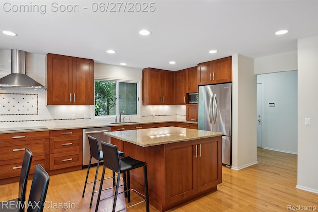 35606 Huntsman Ct, Farmington Hills, MI 48331 - kitchen featuring appliances with stainless steel finishes, wall chimney range hood, backsplash, a center island, and light wood-type flooring