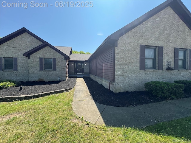 3163 Mystic Valley Dr, White Lake, MI 48383 - view of property exterior with brick siding and a lawn