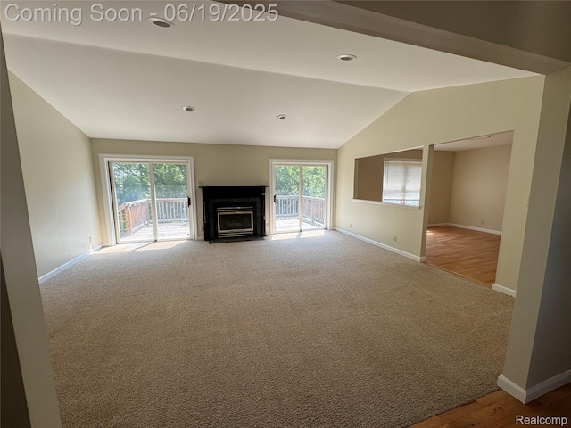 3163 Mystic Valley Dr, White Lake, MI 48383 - unfurnished living room with lofted ceiling, carpet floors, and a fireplace with flush hearth