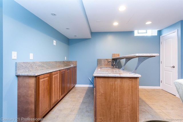 23640 Woodside Ct, South Lyon, MI 48178 - kitchen featuring a peninsula, light stone countertops, recessed lighting, brown cabinetry, and light tile patterned flooring
