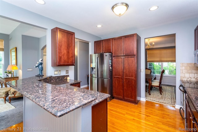 23640 Woodside Ct, South Lyon, MI 48178 - kitchen with appliances with stainless steel finishes, a peninsula, light wood-style floors, arched walkways, and recessed lighting