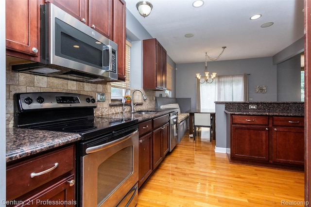 23640 Woodside Ct, South Lyon, MI 48178 - kitchen featuring stainless steel appliances, healthy amount of natural light, light wood-style flooring, a chandelier, and recessed lighting