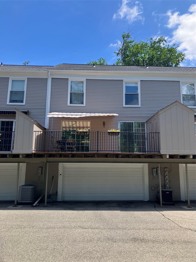 1437 Lantern Ln, Rochester Hills, MI 48306 - back of property with an attached garage, asphalt driveway, and roof with shingles