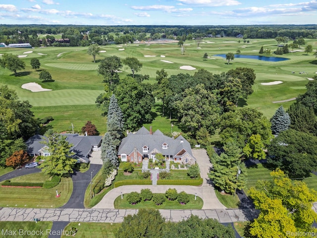 aerial view of property and surrounding area with a nearby body of water and a golf club