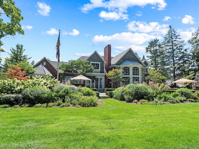 rear view of property with a lawn and a chimney