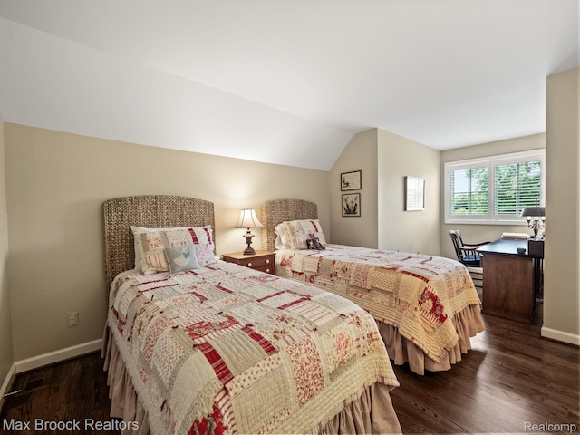 bedroom featuring dark wood-style flooring and vaulted ceiling