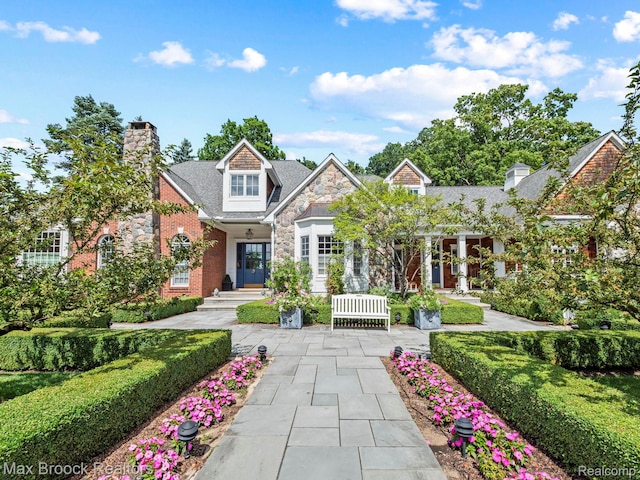 craftsman inspired home with a chimney, stone siding, and french doors